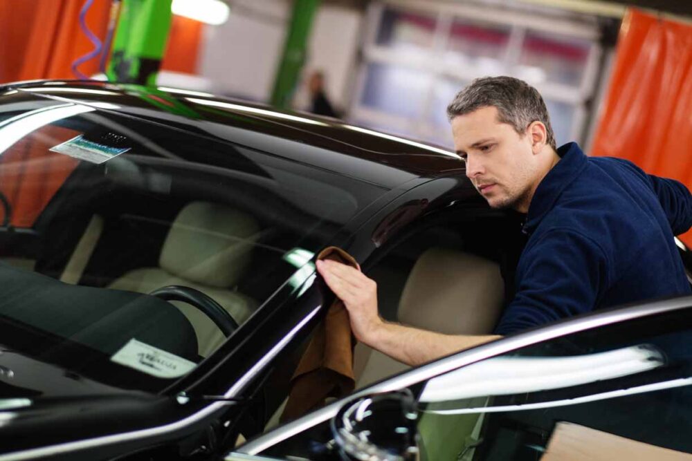 man cleaning black car